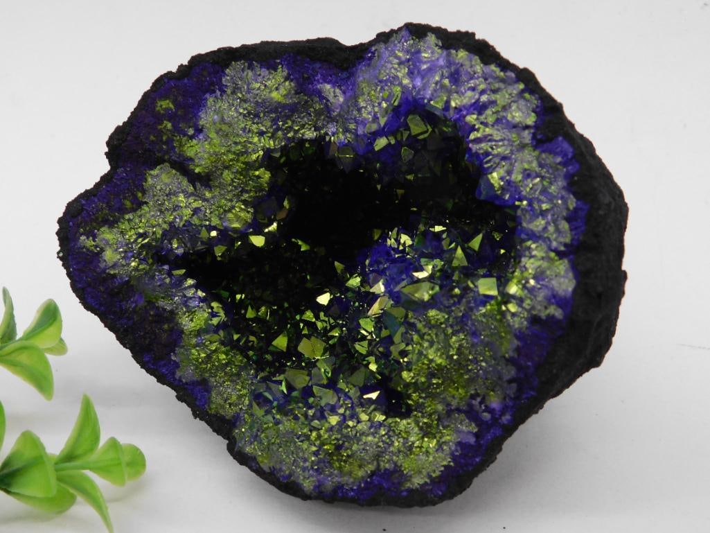 Vibrant Blue and Green Mineral Geode Specimen: This mineral geode specimen features a vibrant display of blue and green colors with shimmering crystalline formations. The geode's exterior is naturally textured while the inner surface exhibits 