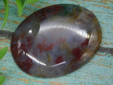 Polished Gemstone With Red And Green Inclusions