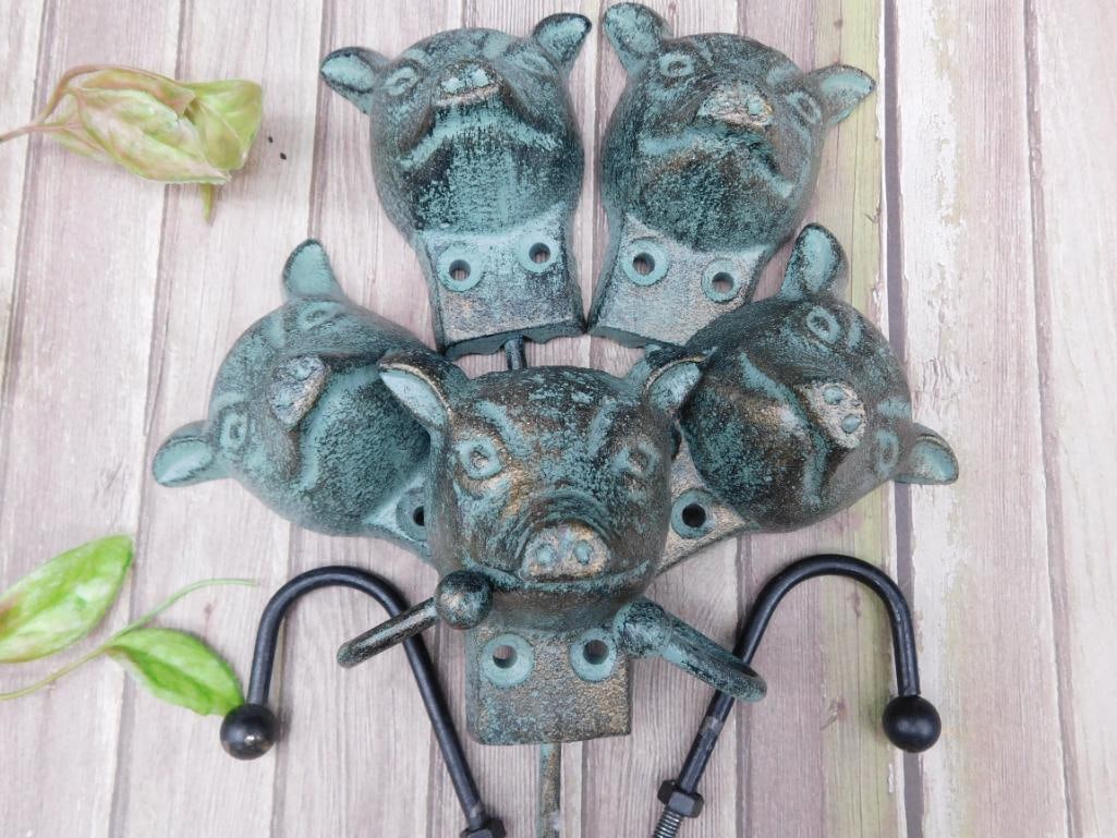 Set of 5 Cast-Iron Animal Shaped Wall Hooks: Set of 5 cast-iron hooks featuring animal-shaped designs, possibly resembling pig or dog heads. Each hook includes a double-hole mount for secure wall placement. Hooks are painted and aged for a rusti