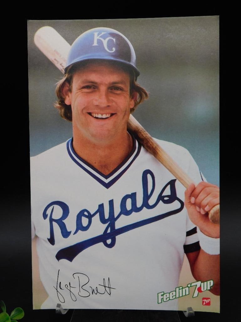 George Brett 7UP Poster with Signature: George Brett Kansas City Royals promotional poster featuring a printed facsimile signature. Produced as part of a 7UP promotional campaign. Includes vibrant graphics showcasing Brett in Royals attire.