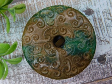 Carved Stone Disk with Swirl Pattern and Central Hole