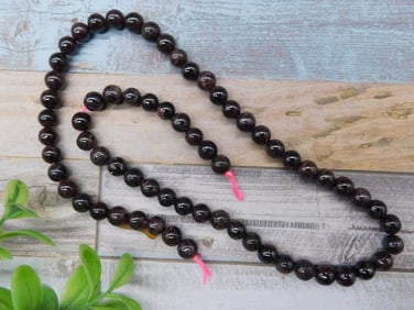 Strand of Garnet Dark Beads With Pink Thread Ties