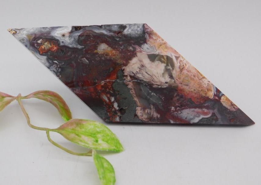Polished Freeform Rhomboid ROCK STONE LAPIDARY SPECIMEN: A unique freeform rhomboid-shaped polished stone with a multi-colored surface featuring intricate patterns of red, white, black, and brown. Ideal for collectors, lapidary work, or display. The stone i