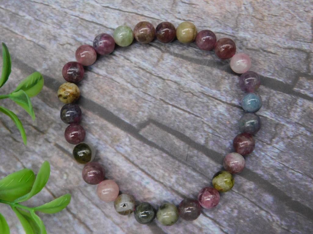 Multi-Color Round Beaded Bracelet Rock Stone Lapidary Specimen: This bracelet features round beads in a variety of colors, creating an eye-catching design. The beads are strung together using an elastic cord for adjustable sizing. The multi-colored beads include s