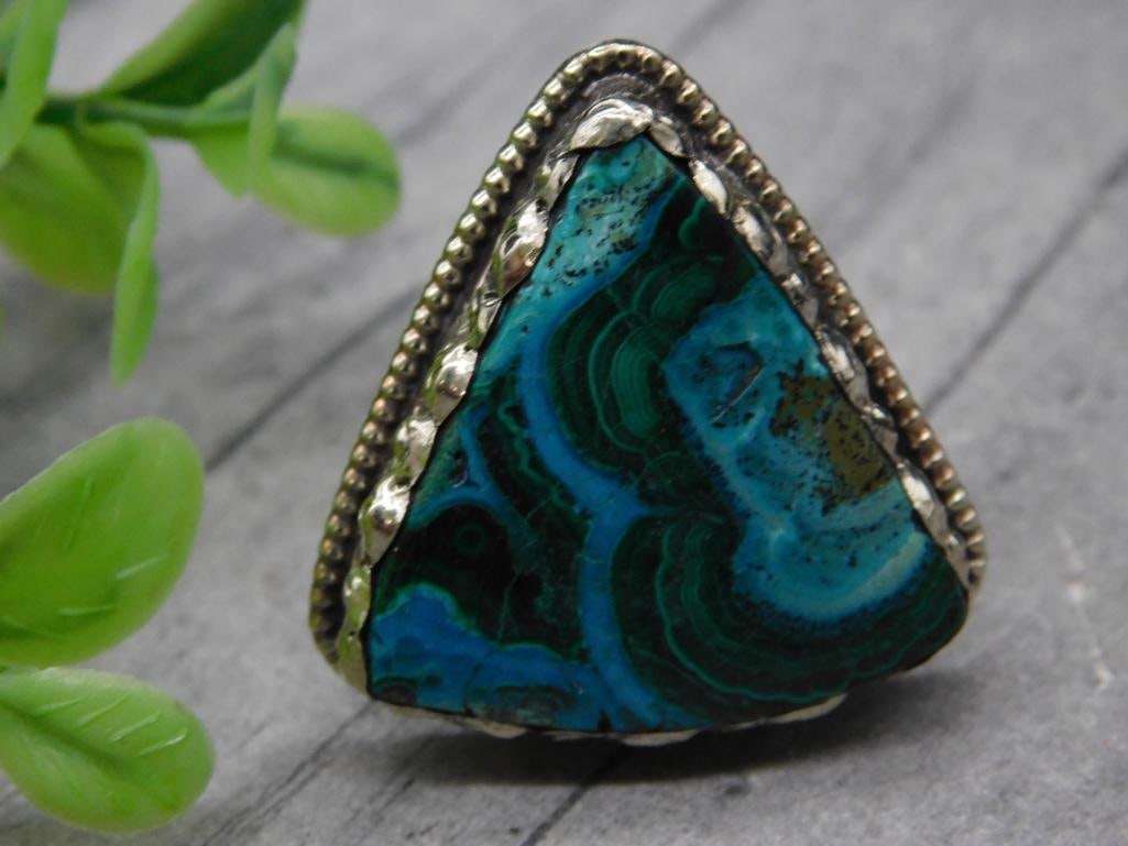 TriangleChrysocolla with Malachite Stone Adjustable Ring ROCK STONE LAPIDARY SPECIMEN: Triangular ring featuring a green and blue stone with swirled patterns, set in a metal bezel with decorative edging. The back shows a textured metal design and an adjustable band for flexible sizing.