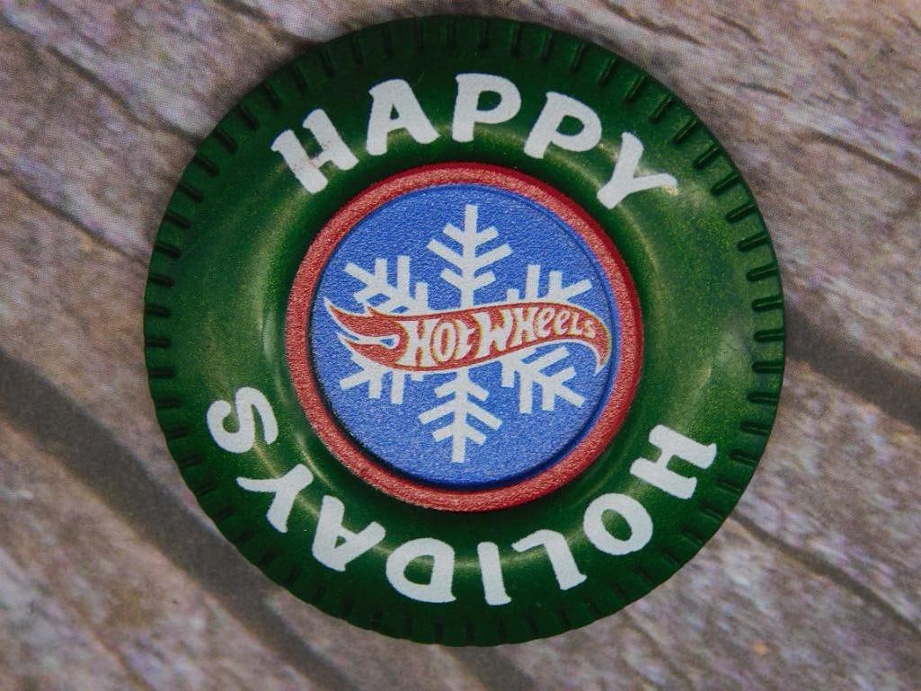 Happy Holidays Token with Snowflake Design: Green token featuring the words 'Happy Holidays' on the front, encircling a central design of a snowflake and stylized text. The back of the token is solid green with a small molded circular detail. P