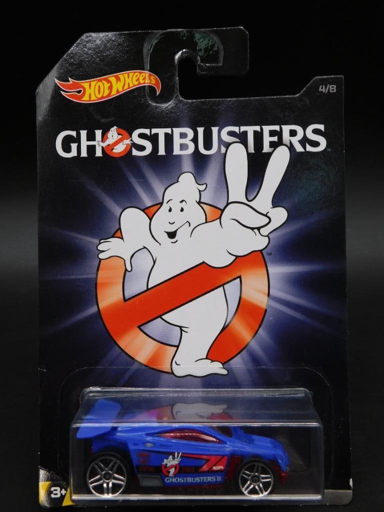 Hot Wheels Ghostbusters Car in Original Packaging: Hot Wheels Ghostbusters-themed die-cast vehicle, presented in its original sealed packaging. The packaging features Ghostbusters branding and an illustration of the iconic logo. Back of packaging incl