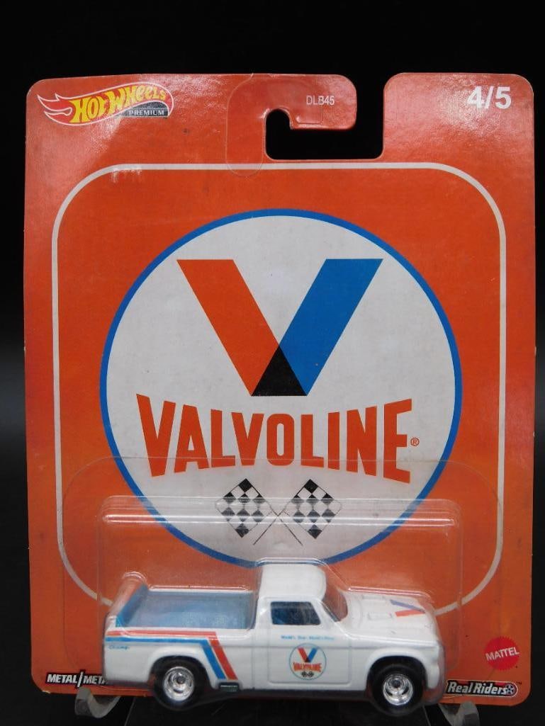 Hot Wheels Valvoline Die-Cast Truck in Original Packaging: Hot Wheels die-cast truck featuring Valvoline branding and racing decals. The collectible is part of a series, marked as '4/5' on the packaging. It is preserved in its original blister pack and appear