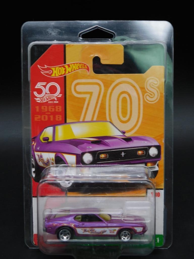 Hot Wheels 50th Anniversary ?70s Mustang Die-Cast Car: Hot Wheels 50th Anniversary '70s Mustang die-cast car from the 2018 series. Features purple paint with decals representing 1970s styling. Packaged in original, unopened manufacturer blister pack, show