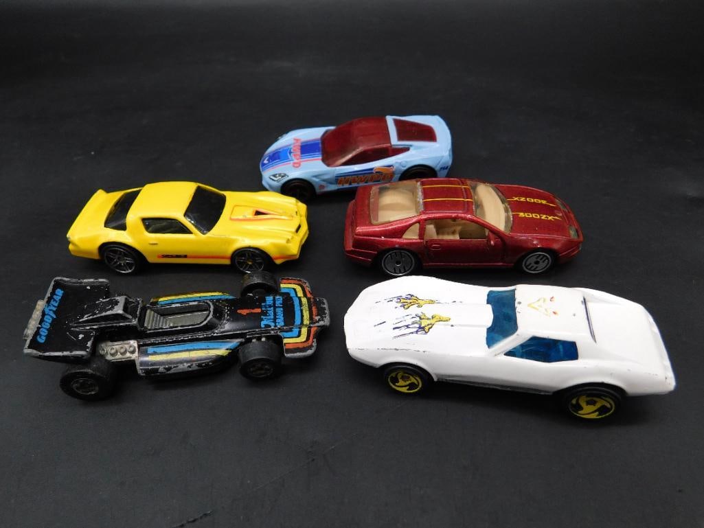 Lot of 5 Die-Cast Hot Wheels Toy Cars: This collection includes five die-cast Hot Wheels toy cars featuring various designs and colors. Each car displays intricate detailing on both the exterior and the underside, with markings such as 'Ho