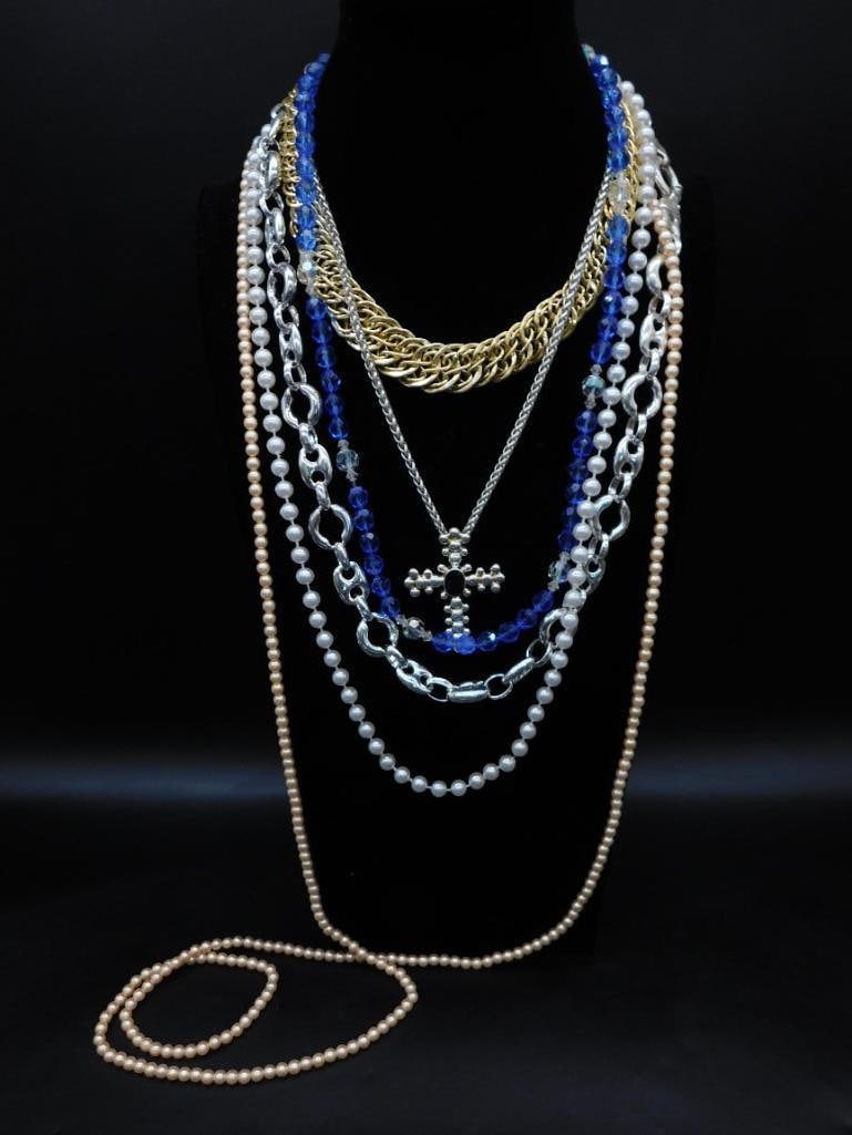 Collection of Beaded and Chain Necklaces With Cross Pendant: This collection includes multiple necklaces featuring beads, chains, and a cross pendant. The set comprises gold-tone, silver-tone chains, faux pearls, blue faceted beads, and a silver-tone cross ador