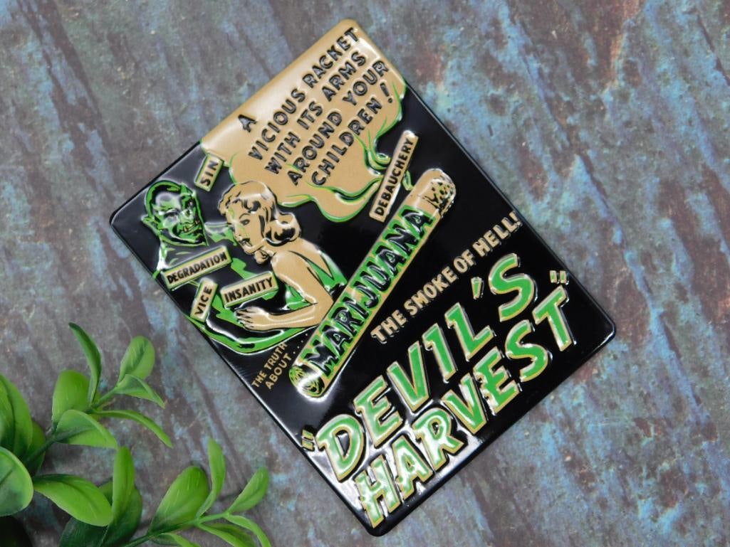 Vintage-Style Devils Harvest Tin Magnet: A tin sign featuring the title 'Devil's Harvest' with dramatic anti-marijuana propaganda artwork and captions. Lightweight and compact design, ideal for display or collection. Dimensions are unspecifi