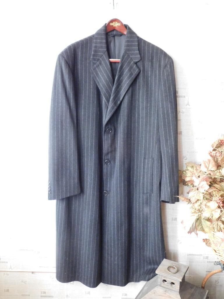 Men?s Pinstripe Wool Overcoat in Navy and Grey: Men's wool overcoat featuring a navy-blue base with grey pinstripes. Single-breasted design with a three-button closure. Includes a notch lapel, two front pockets, and a rear vent for added mobility. 