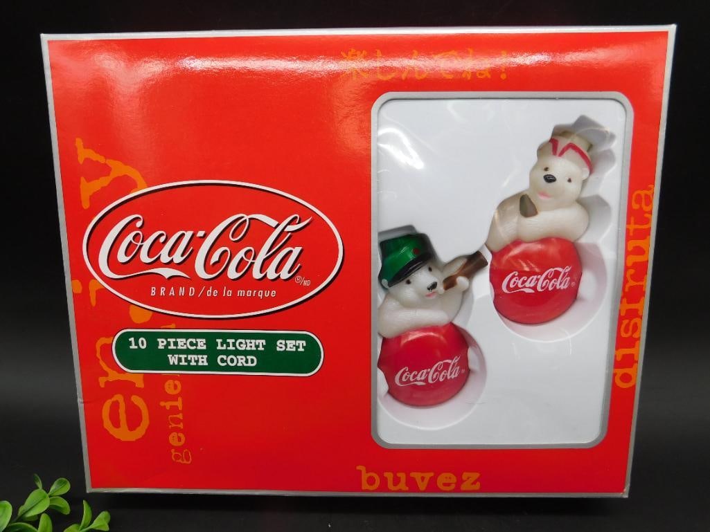 Coca-Cola 10 Piece Light Set with Cord: This is a Coca-Cola branded 10 piece light set with cord, featuring holiday-themed polar bear designs. The set appears to be new and comes in its original packaging. It displays the iconic Coca-Cola b