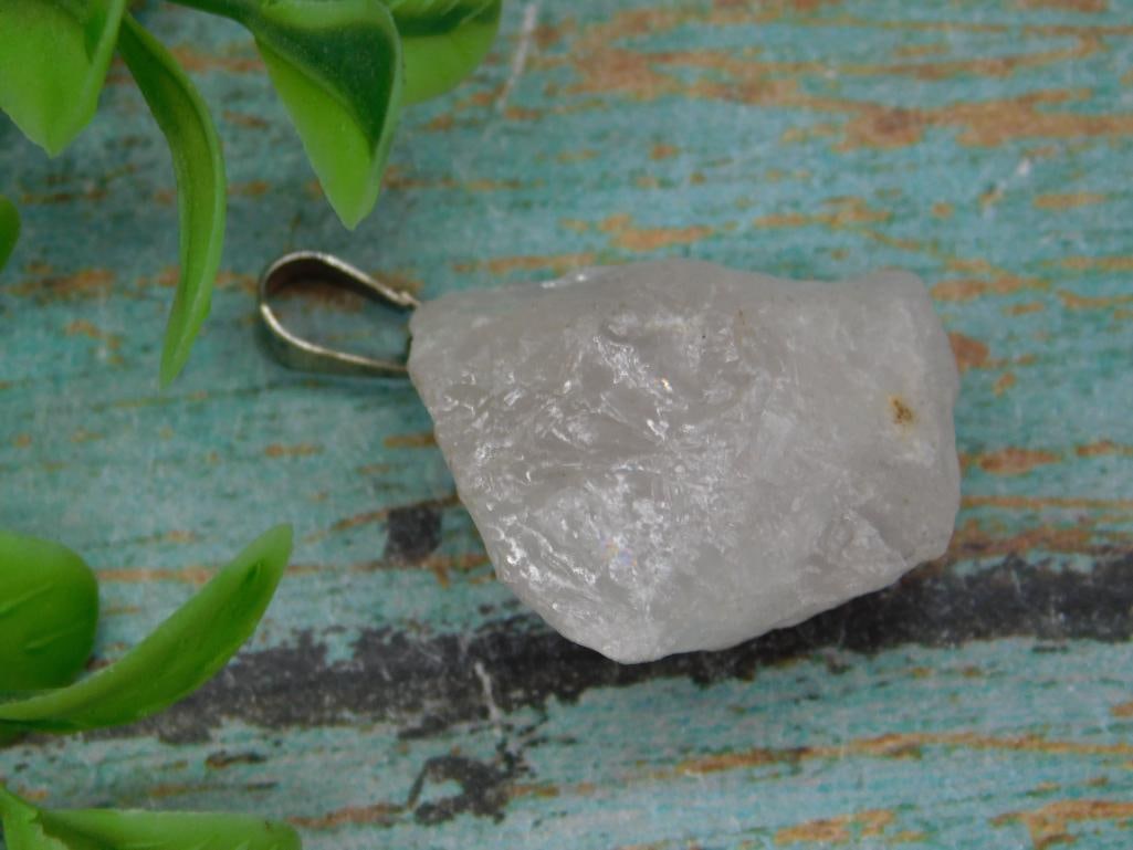 Raw White Gemstone Pendant ROCK STONE LAPIDARY SPECIMEN: Raw white gemstone pendant featuring a natural, unpolished stone. Attached is a metal bail for use with a chain or cord. Includes a ruler comparison for approximate size reference. Lightweight and sui