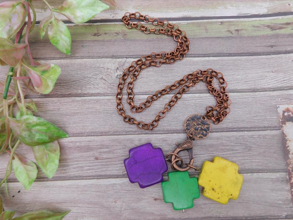Copper Chain Necklace with Colorful Cross Pendants: This necklace features a copper link chain paired with three colorful cross-shaped pendants in purple, green, and yellow. The chain is detailed with an elegant round copper charm near the closure, add