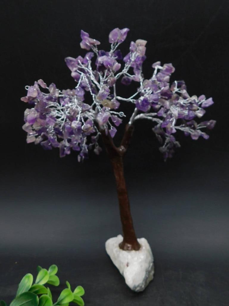 Amethyst Gemstone Wire Tree on Mineral Base: Decorative tree made with twisted silver-tone wire and adorned with amethyst gemstone chips to form the foliage. Secured onto a mineral base for stability, featuring a natural stone appearance. Approx