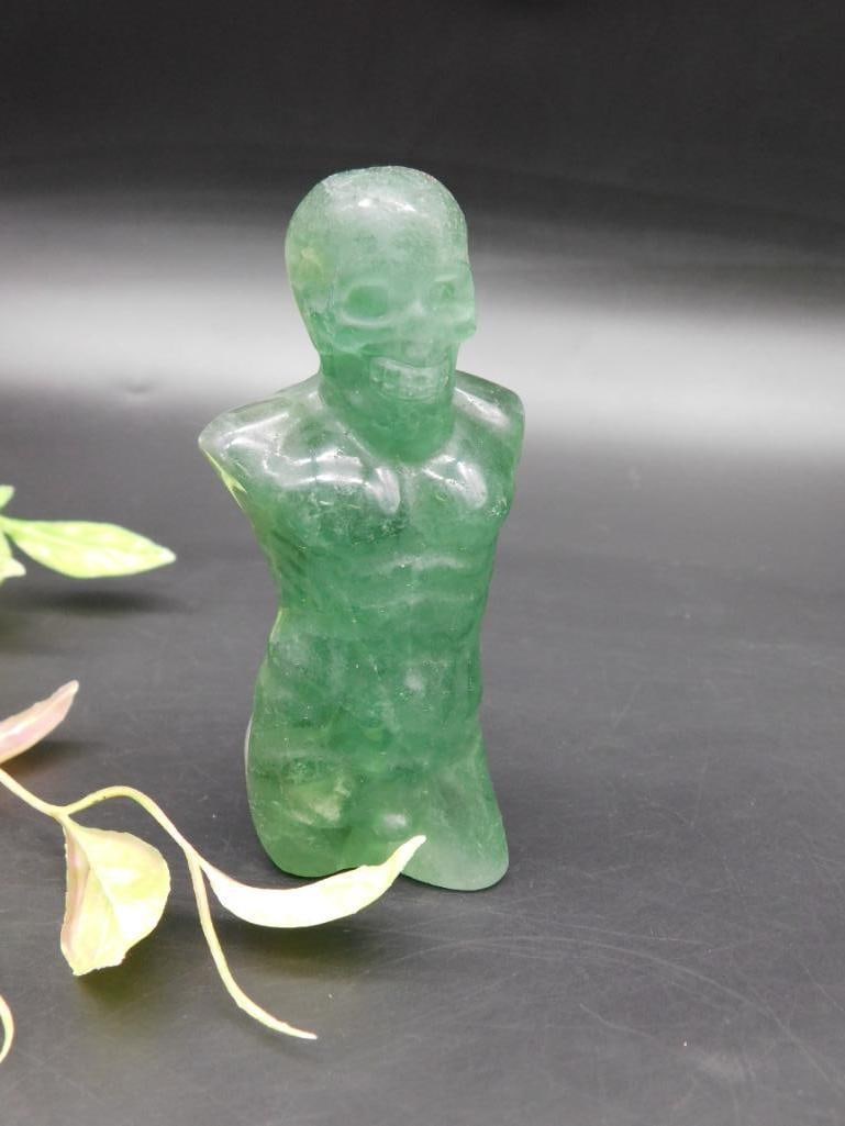 Green Stone Carved Human Form Figurine ROCK STONE LAPIDARY SPECIMEN: Green hue stone-like figurine carved in the form of a human torso with skull features. Depicts head, chest, and upper torso. Smooth finish with visible carving details. Approximate height provided in 