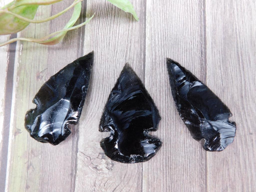 Set of Three Flaked Black Obsidian Arrowheads ROCK STONE LAPIDARY SPECIMEN: This lot includes three hand-flaked black obsidian arrowheads. Each piece features sharp edges and a glossy surface, characteristic of obsidian. The arrowheads vary slightly in size, approximately 1.5