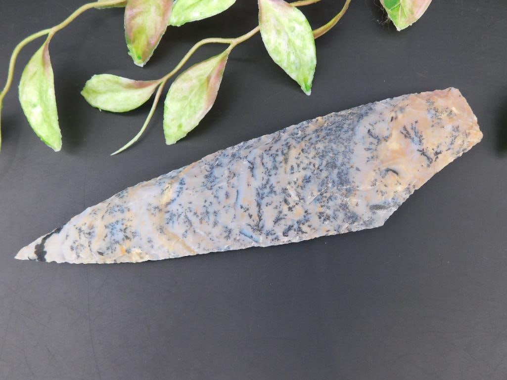 Chert Stone Blade With Engraved Pattern: This chert stone blade features a detailed engraved surface and a sharpened edge. Measuring approximately 8 inches in length, it weighs 105 grams, as indicated. The item is well-suited for collectors 