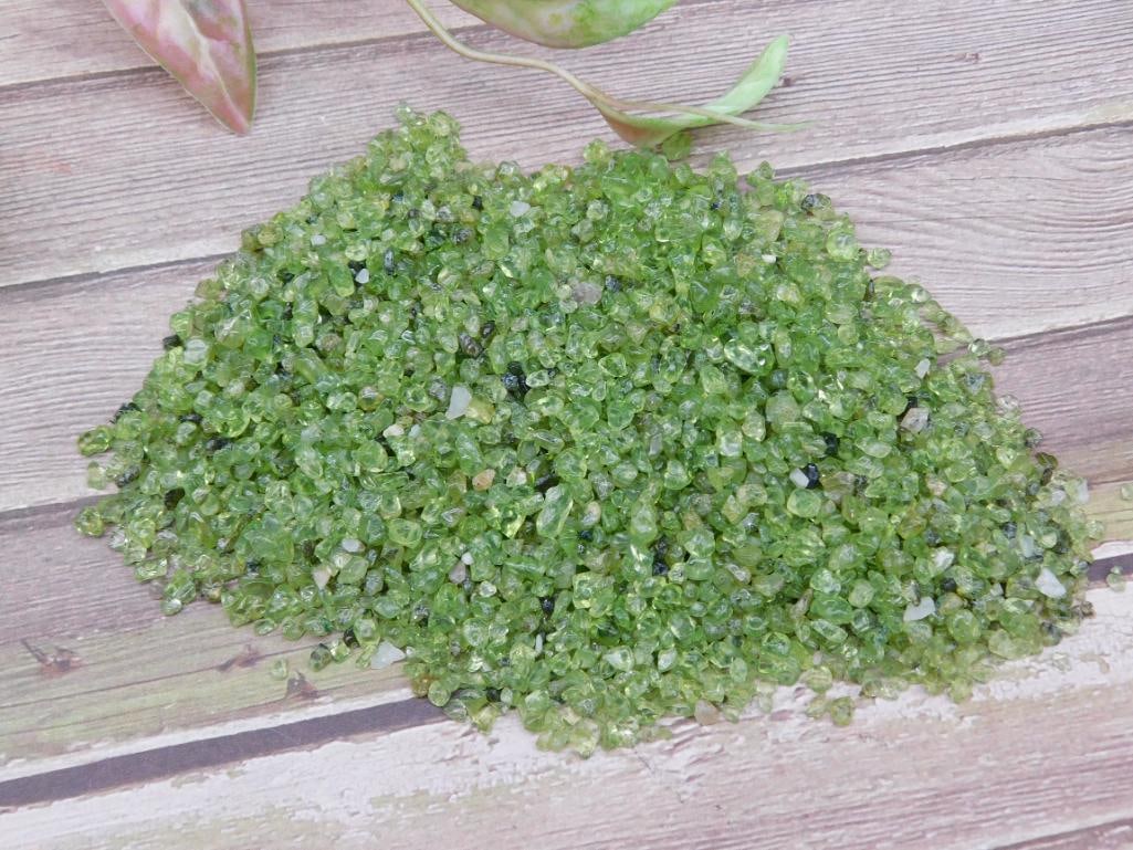 Peridot Gemstones 100 Grams: A lot of finely-sized green Peridot gemstones with an approximate weight of 100 grams. These stones are suitable for crafting, jewelry making, or collecting. The stones vary in size and are displayed 