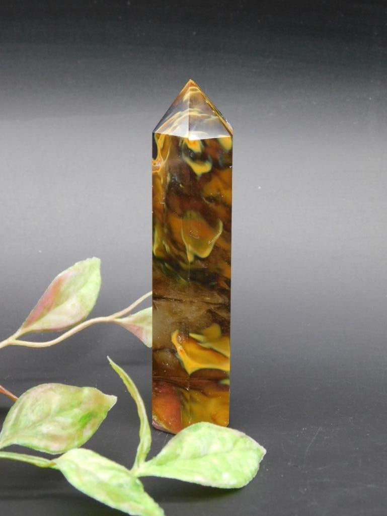Faceted Brown and Yellow Obelisk Decorative Stone: A small decorative faceted obelisk-shaped stone featuring vibrant brown and yellow hues with a smooth polished surface. Double-pointed and ideal for display purposes. Includes clear size reference in
