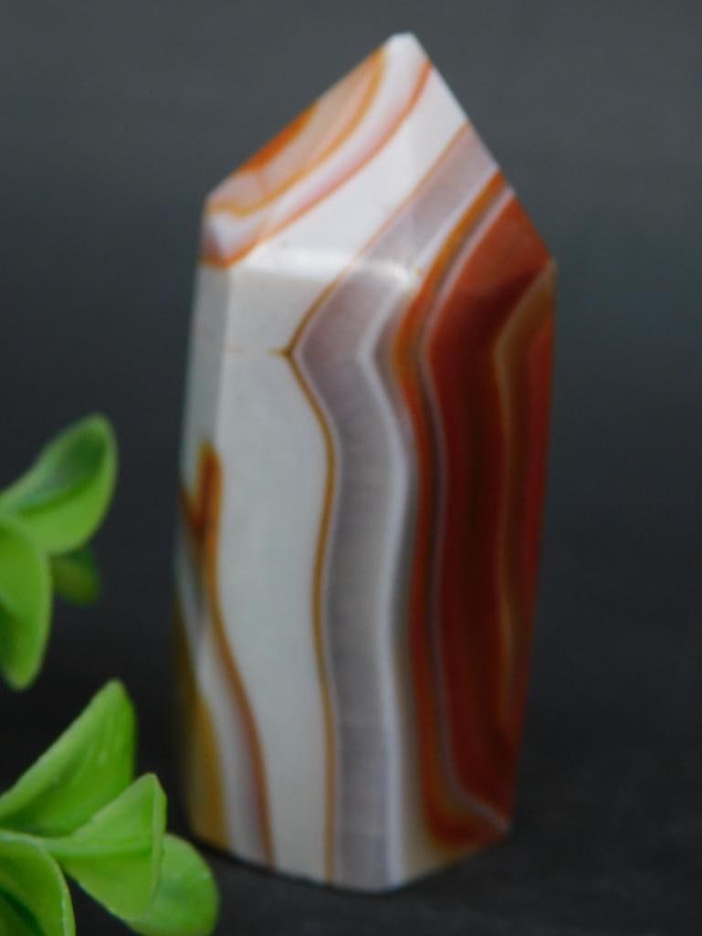 Polished Orange Banded Agate Point: Polished orange banded agate point with distinct layers of orange, white, and red hues. The piece is double terminated and measures approximately 51 grams as indicated. Ideal as a collectible or decor