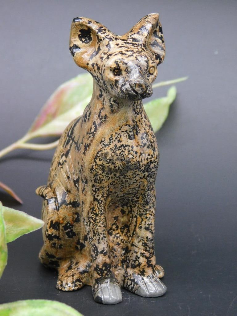 Hand-Carved Spotted Stone Cat Figurine: Hand-carved figurine made from spotted stone material, resembling an animal, possibly a deer or antelope. Features intricate patterns and polished surfaces. Includes hoof details and natural stone tex