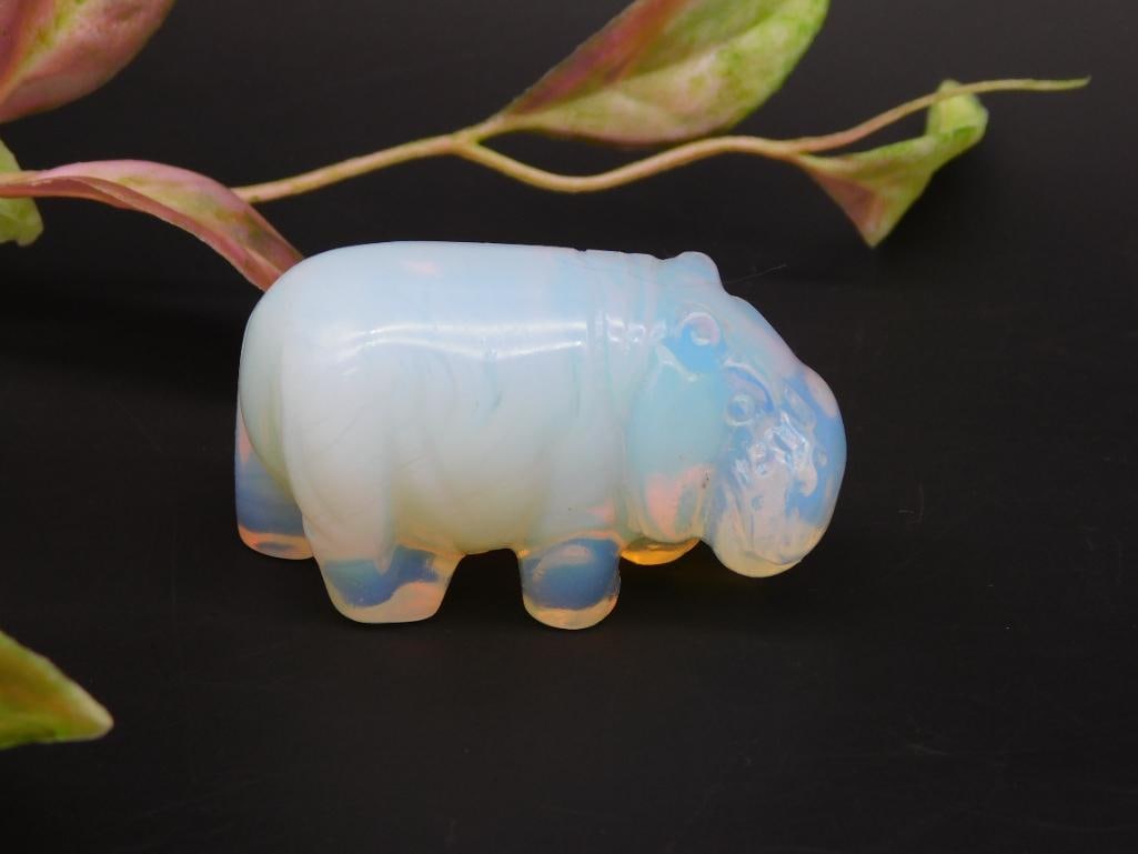 Opalite Hippopotamus Figurine: This opalite hippopotamus figurine showcases a smooth, polished finish with a translucent and iridescent appearance. Ideal for collectors or as a decorative item. Measures approximately 2 inches in le