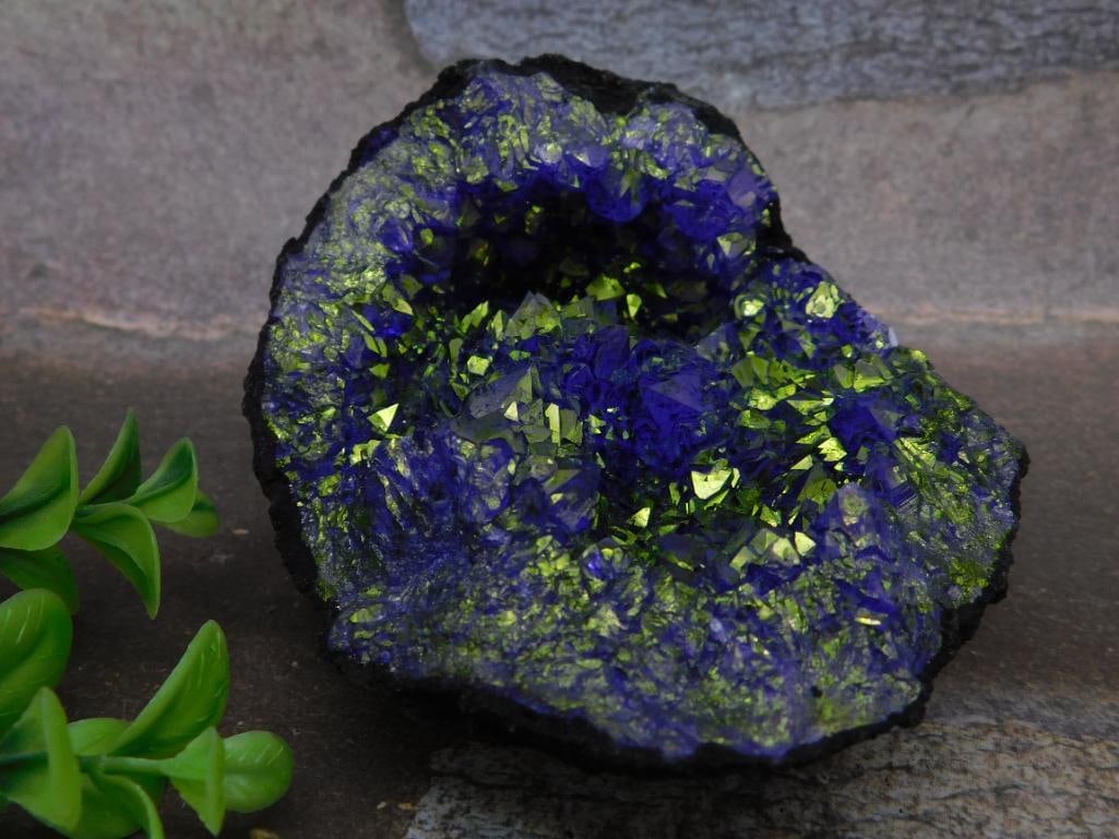 Geode With Vibrant Purple and Green Crystal Formation: This stunning geode features a vibrant purple and green crystal formation with intricate, natural crystalline structures. The geode weighs 379 grams, as indicated in the provided information. The vivi
