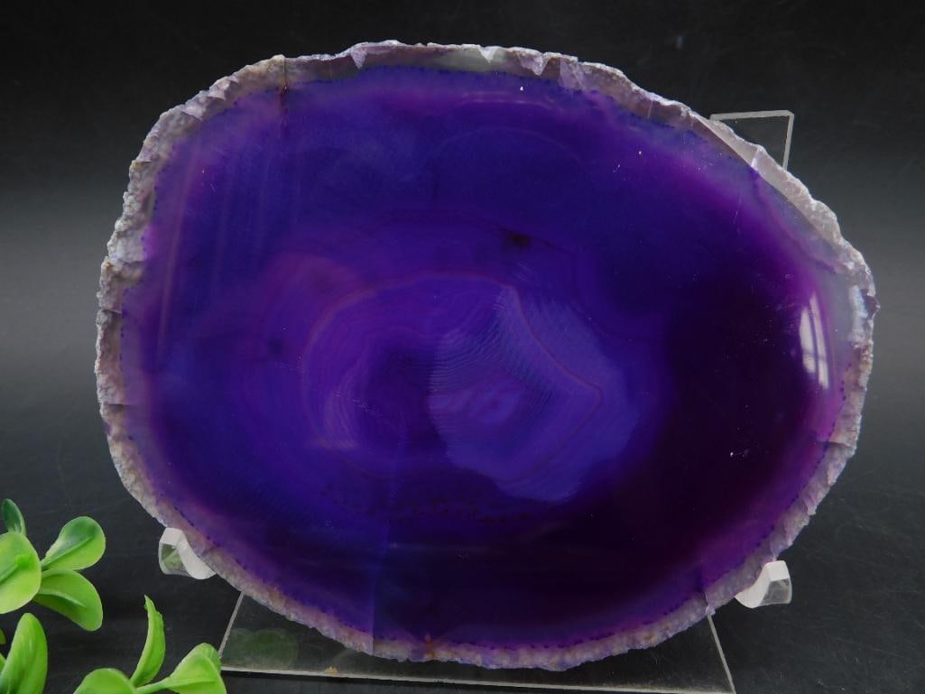 Polished Purple Agate Slice: A polished purple agate slice featuring vibrant coloration and natural banding patterns. Comes with a clear display stand to showcase its beauty. The overall size provides a visually striking piece fo