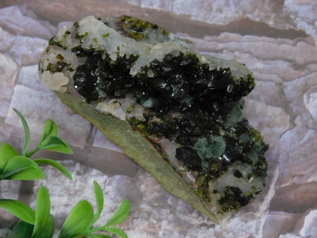 Epidote Crystal Mineral Specimen: Unique mineral specimen featuring a quartz matrix with clusters of green crystals. Attractive natural formation. Approximate weight is 165 grams as indicated. Includes a natural base for display purpo