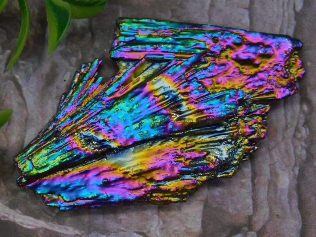 RAINBOW KYANITE With Iridescent Finish: A bismuth crystal exhibiting a vibrant iridescent surface with colorful metallic hues. The unique geometric structure is naturally formed with stepped edges and layered visual texture. Lot card includ