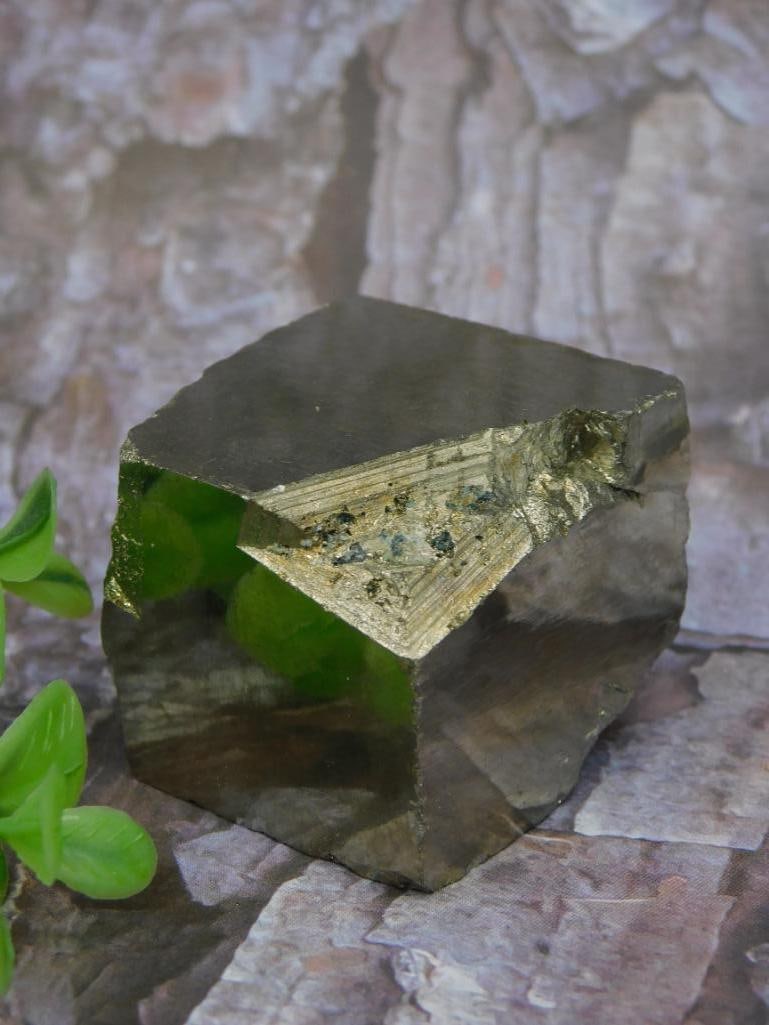 NATURAL SPANISH PYRITE CUBE ROCK STONE LAPIDARY SPECIMEN: Specimen of pyrite displaying a distinct geometric crystal formation. The piece features a natural inclusion resembling a moth, highlighting its organic and intricate qualities. Accompanied by a scale