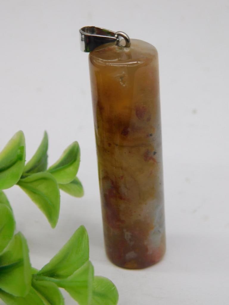 AGATE CYLINDER PENDANT ROCK STONE LAPIDARY SPECIMEN: This lot features a polished stone pendant with a cylindrical shape and a mix of colors. The pendant includes a metal bail for convenient attachment to a necklace or chain. It weighs 20 grams, as mark