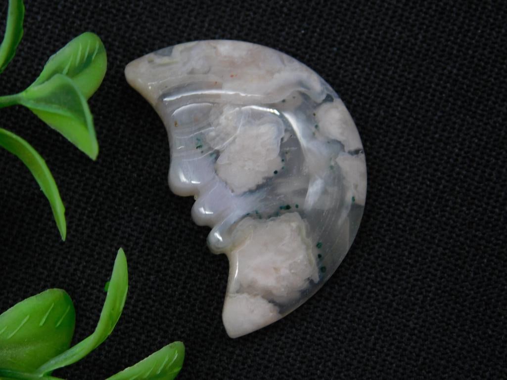 CARVED CRESCENT MOON MOSS PLUME AGATE ROCK STONE LAPIDARY SPECIMEN: This lot features a delicate carved moon face made from agate stone. The unique patterns of the agate are visible throughout, showcasing natural inclusions and banding. Its compact size is ideal for d