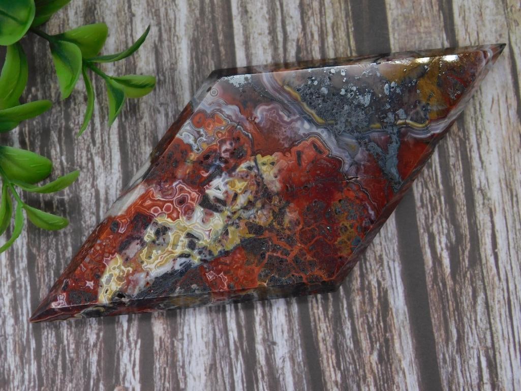 Polished Diamond-Shaped Agate Specimen ROCK STONE LAPIDARY SPECIMEN: This beautifully polished diamond-shaped agate specimen showcases vivid colors and intricate patterns. The specimen measures 151 grams, as indicated, and features an array of red, white, yellow, and d