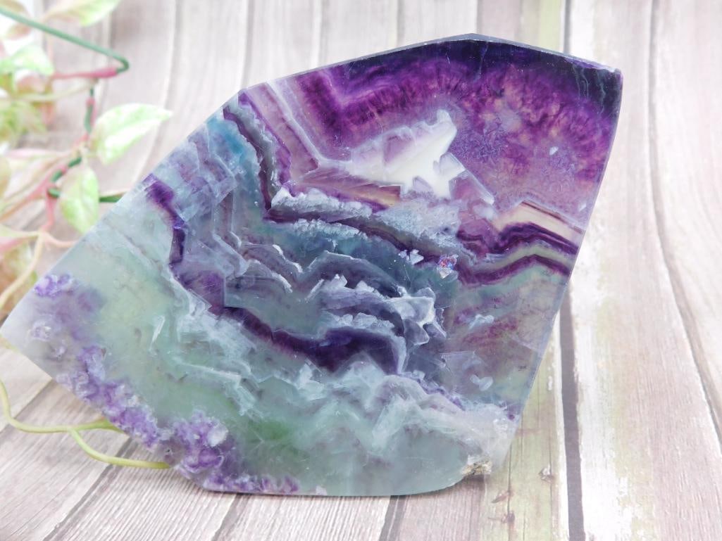 Purple and Green Banded Fluorite Rock Stone Lapidary Specimen: This listing features a striking purple and green banded fluorite stone slab. Weighing 170 grams, this polished slab showcases vibrant, natural banding patterns. Its polished surface highlights the in