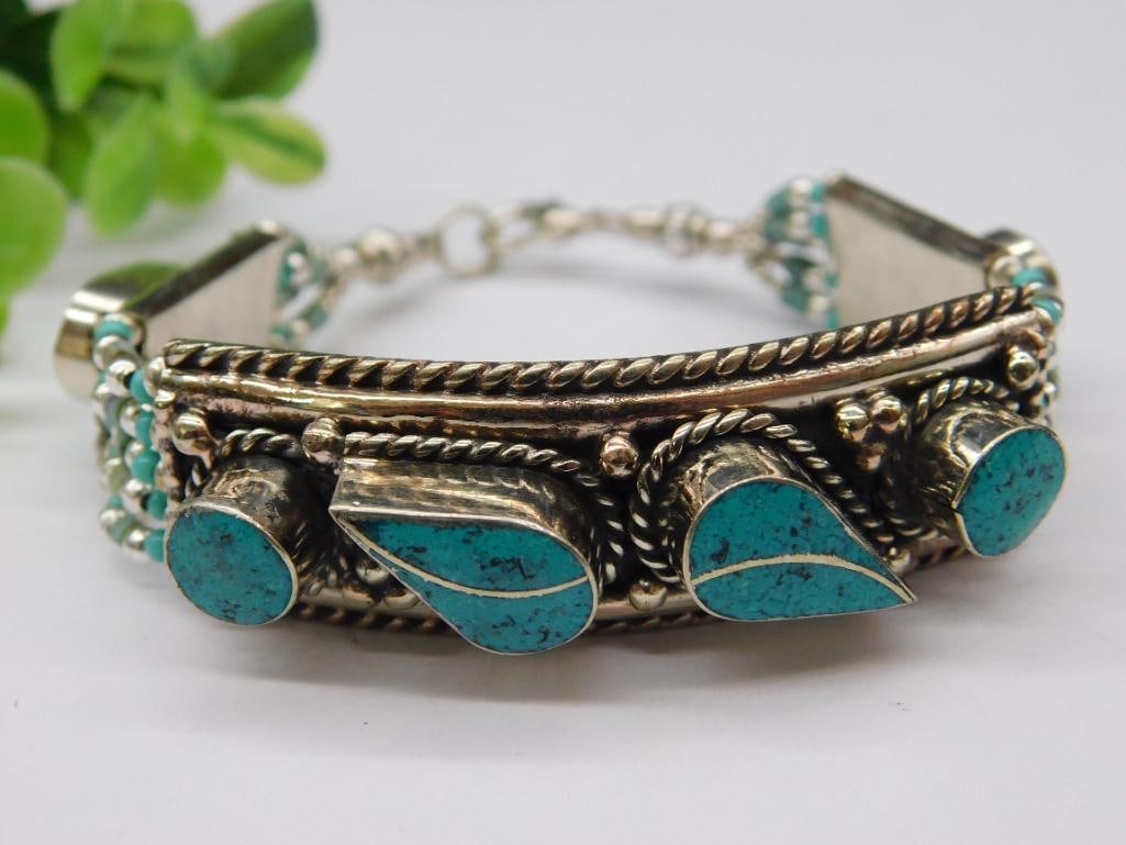 Turquoise Bracelet With Decorative Inlay: - Silver bracelet featuring turquoise stone inlays in a decorative pattern. | - Design includes three large turquoise stones with a teardrop motif and smaller turquoise bead accents. | - Features a ho