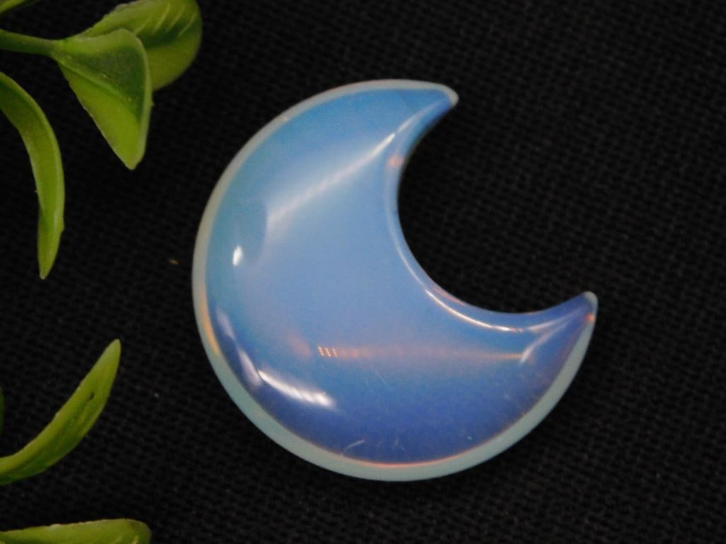 Opalite Crescent Moon-Shaped Decorative Stone Rock Stone Lapidary Specimen: - Crescent moon-shaped decorative piece made of opalite. | - Smooth, polished surface with an iridescent appearance. | - Approximate size shown relative to a US quarter coin for scale. | - Ideal for c