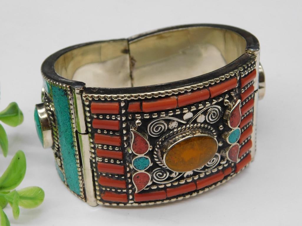 Vintage Hinged Bracelet With Coral and Turquoise Inlay Rock Stone Lapidary Specimen: - Metal bracelet with a hinged design for ease of wear | - Decorated with coral and turquoise inlay on both sides | - Features oval center stones and intricate silver-toned detailing throughout | - Me