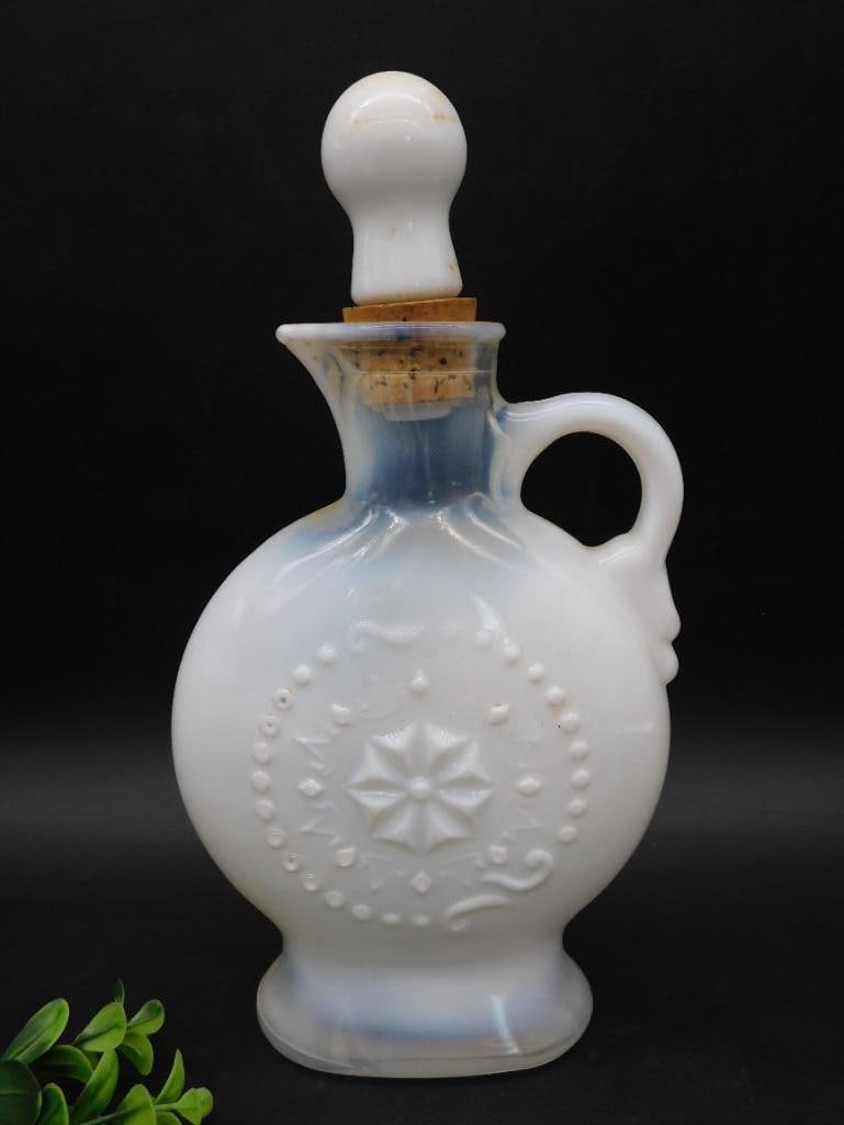 Vintage White Milk Glass Decanter with Starburst Design: - White milk glass decanter featuring a circular starburst and beaded design on both sides. | - Comes with a matching round stopper, fitted with a cork insert. | - Includes a narrow handle for ease of