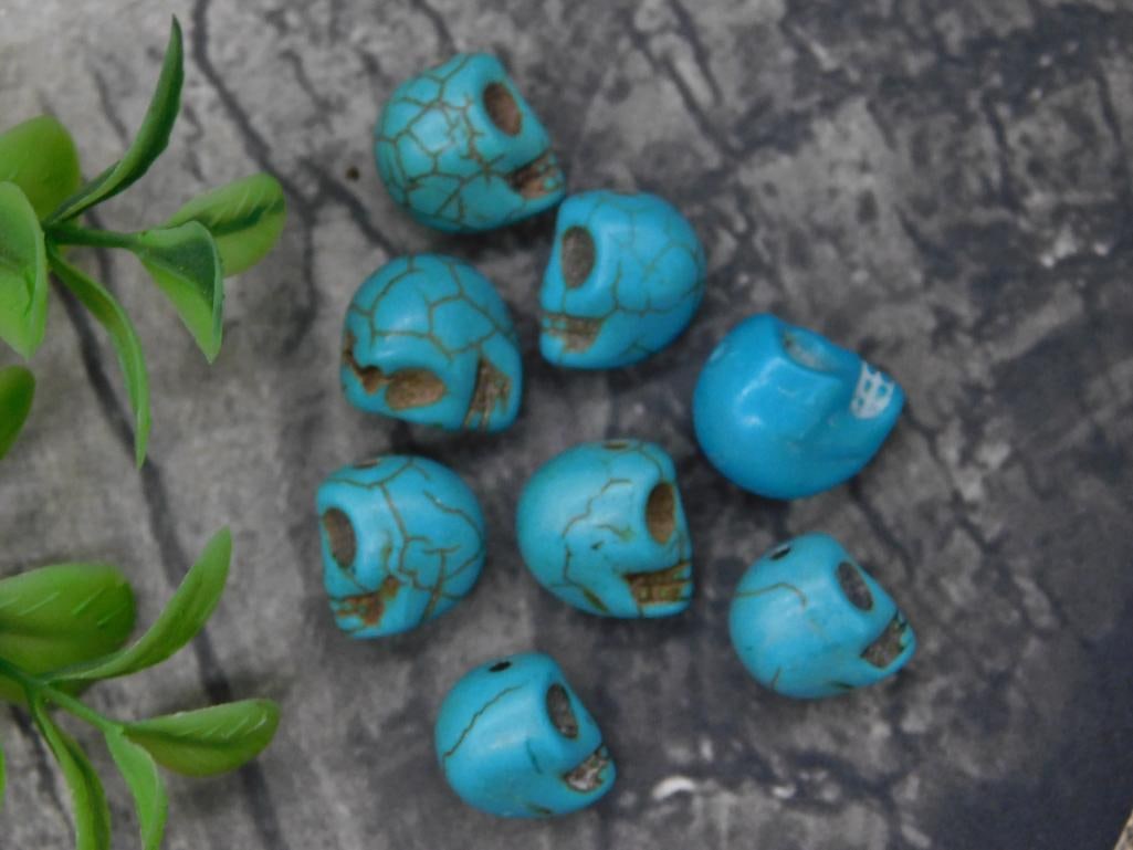 Blue Skull-Shaped Beads for Jewelry Crafting: - Includes several small skull-shaped beads in a striking blue color with stone-like veining. | - Made from a turquoise-style material, possibly dyed or composite stone. | - Each bead is pre-drilled f