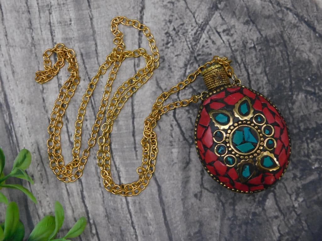 Turquoise and Red Coral Snuff Bottle on Chain: - Features a gold-tone chain with intricate links and a vibrant pendant. | - The pendant includes red and blue inlays arranged in decorative patterns. | - Design showcases a teardrop-like shape enhanc
