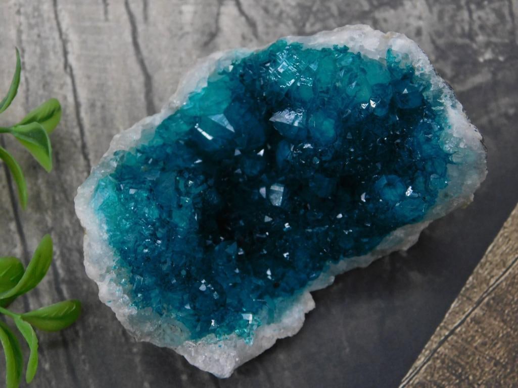Blue Crystal Geode Rock Stone Lapidary Specimen: - Vibrant blue crystal geode with natural formations and crystal inclusions. | - Features detailed druzy surface for enhanced crystalline appearance. | - Comes with display card indicating 103 grams t