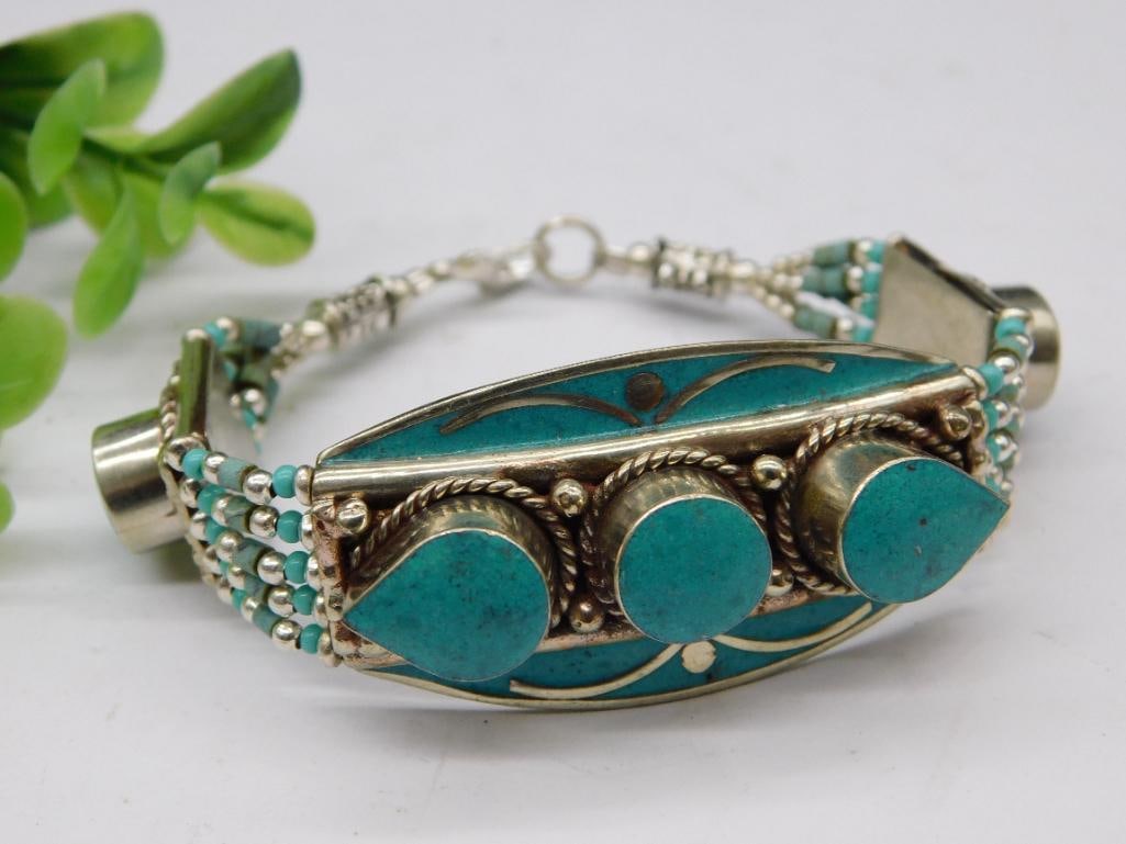 Turquoise and Metal Bracelet: - Handmade bracelet featuring turquoise stones and intricate metal accents. | - Includes five turquoise settings, with a mix of triangular and circular designs. | - Strung with silver-tone and turquoi