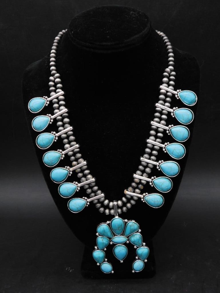 Squash Blossom Fashion Necklace: Crafted with silver beads and intricate metalwork settings. | - Includes a prominent central naja pendant adorned with multiple turquoise accents. | - Traditional design with a likely Navajo or Southw
