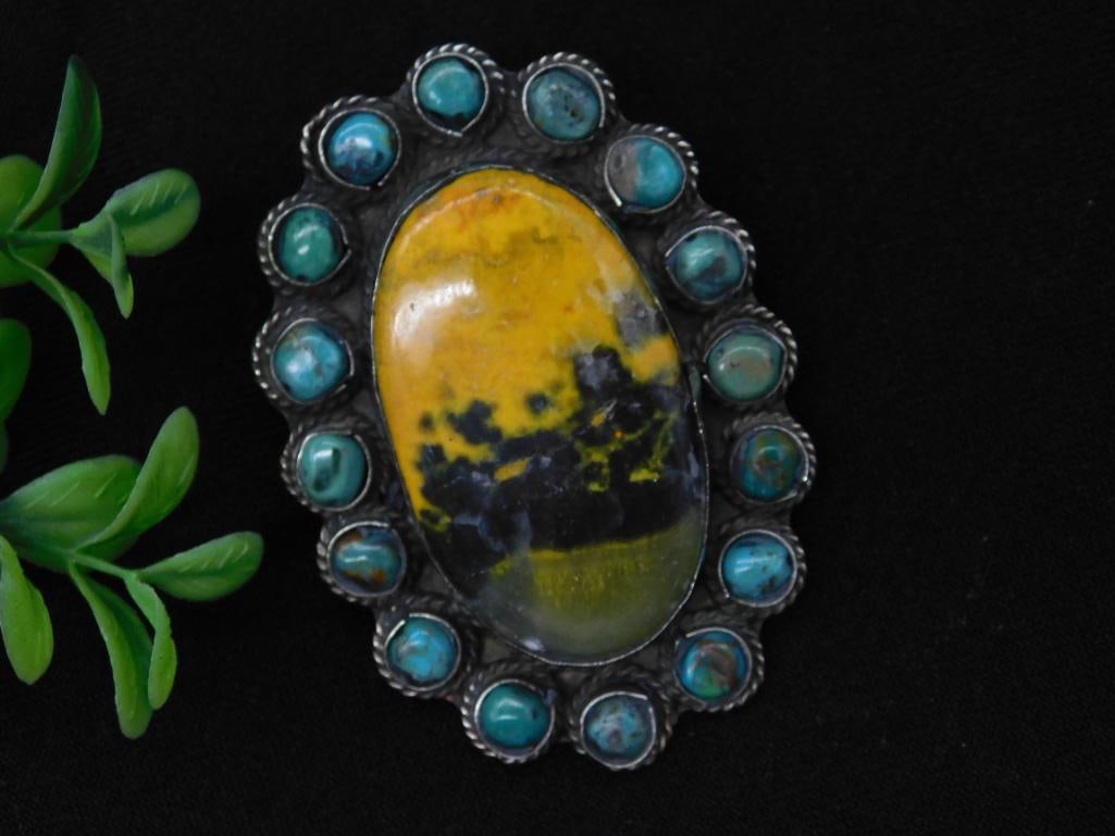 Bumblebee Jasper and Turquoise Pendant Rock Stone Lapidary Specimen: Large pendant featuring a central yellow and black stone surrounded by turquoise cabochons. Decorative silverwork is detailed on the reverse. Pendant includes a large loop for attaching to a chain or