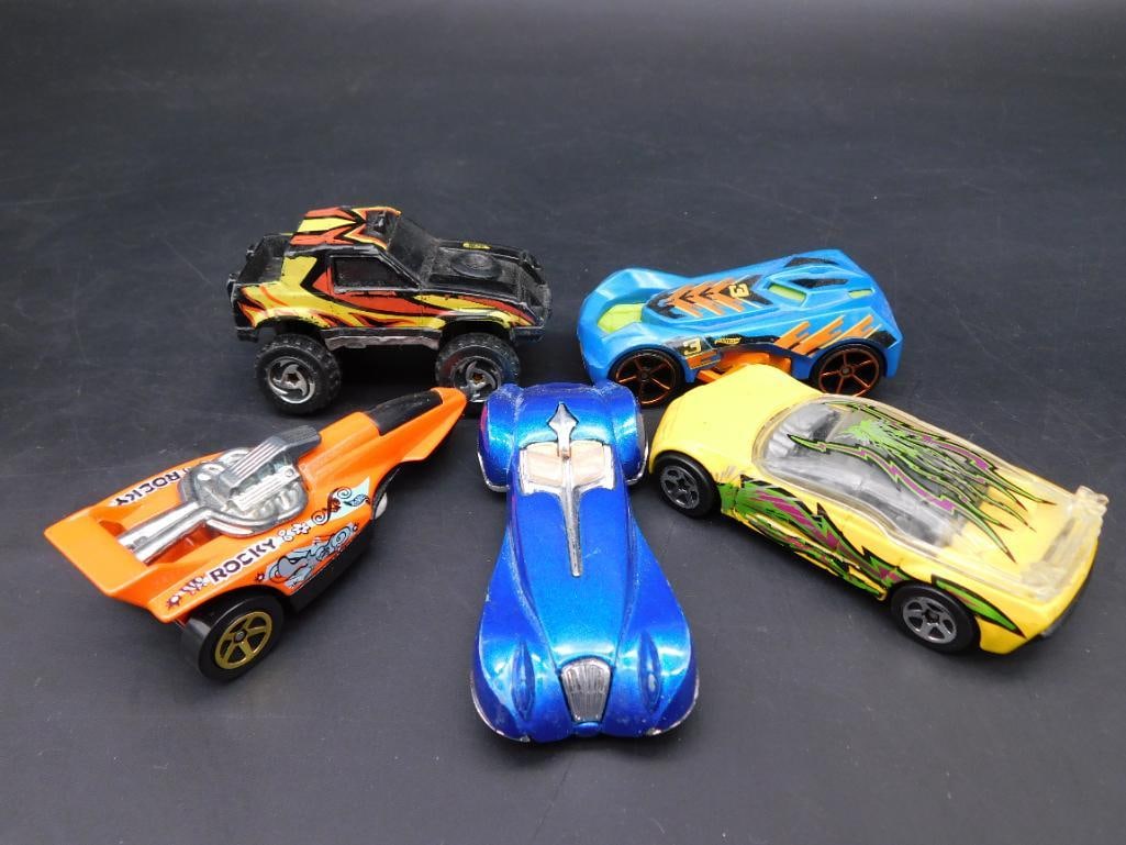 Lot of 5 Assorted Hot Wheels Die-Cast Cars: This lot includes five assorted Hot Wheels die-cast cars featuring vibrant designs and various styles. Markings on the undersides date the models between 1992 and 2004 and indicate production in Malay