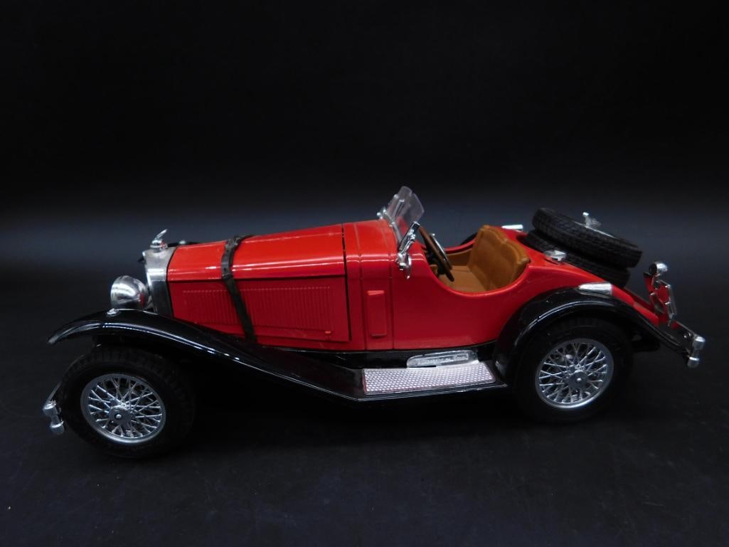 Red Die-Cast Model of a Classic Convertible Car by Bburago: This item is a detailed die-cast model of a classic red convertible car manufactured by Bburago. It features intricate details including chrome accents, a replicate spare tire at the rear, and a tan i